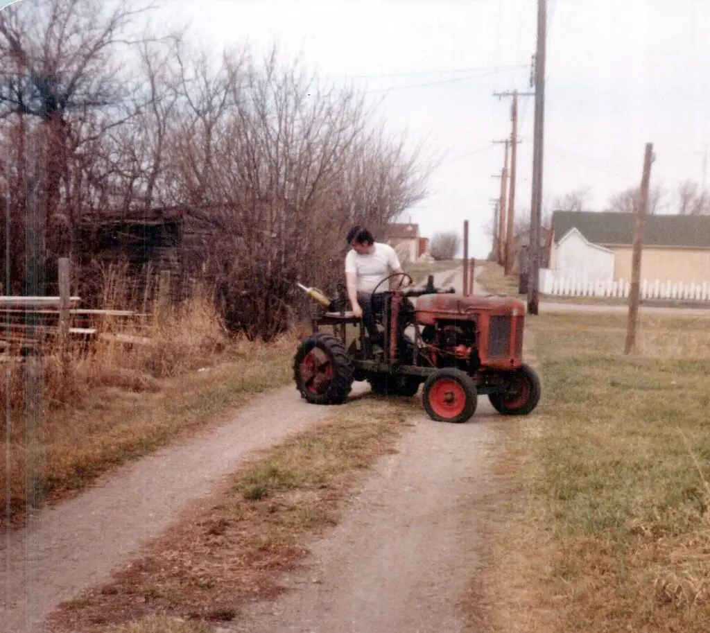 Dan on George's homemade garden tractor — built from an old combine motor, scrap iron and his own ingenuity.